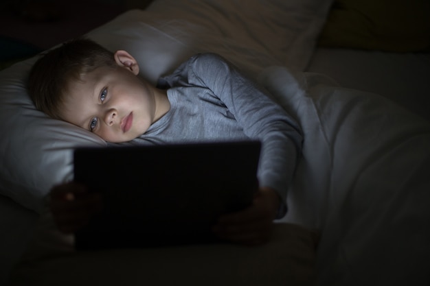 Little Boy die Computer in Bed met behulp van