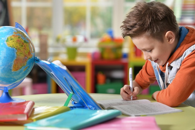 Little boy doing lessons at home in his room