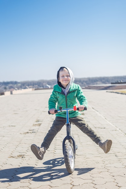 自転車に乗ってトリックをやっている小さな男の子