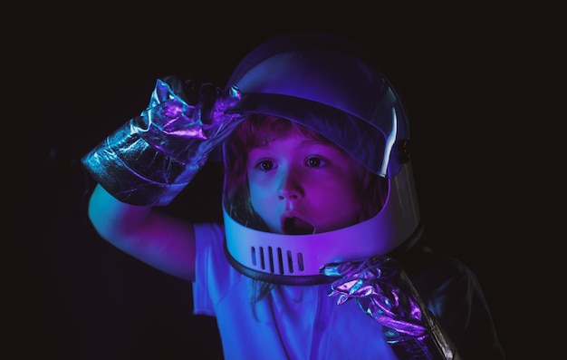 小さな男の子は宇宙飛行士になり、宇宙服を着て宇宙宇宙の子供たちに飛ぶことを夢見ています