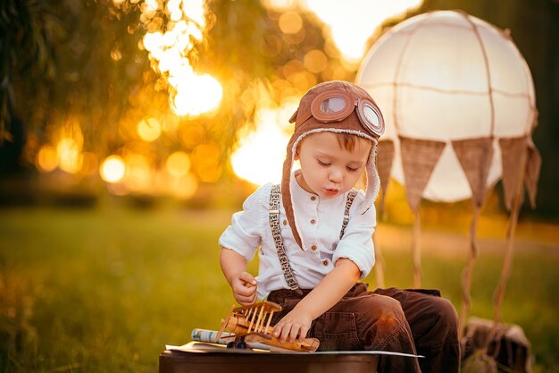 小さな男の子はパイロットのヴィンテージ航空帽子になることを夢見ています