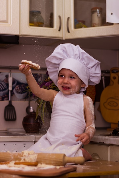 写真 料理人に扮した少年が小麦粉生地をこねる