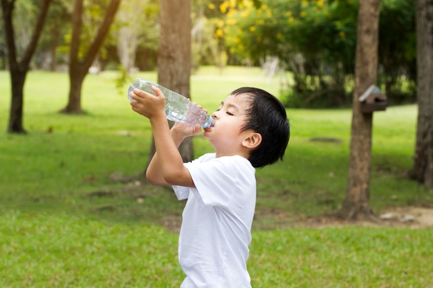 屋外の公園で小さな男の子の飲み水