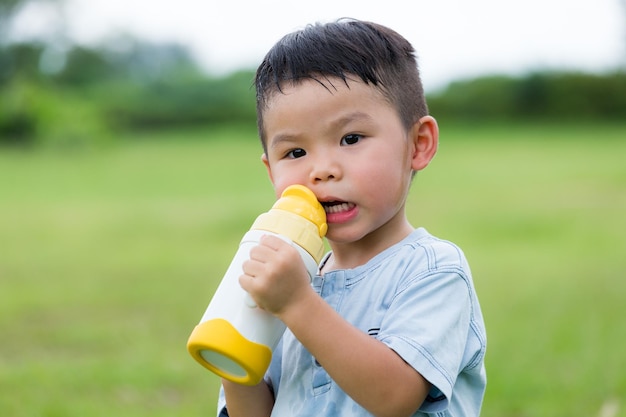 水のボトルで飲む小さな男の子