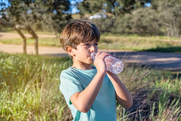 冷やすために水を飲む小さな男の子