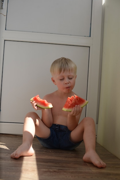 ジューシーなスイカを食べる小さな男の子