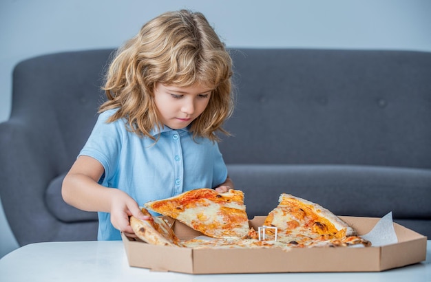 Little boy eating pizza Cute little boy eats pizzas Happy handsome young teen boys holding slice pizza Little boy holding pizzas boxes Boy ready to eat pizza Little child looking at a pizzas box