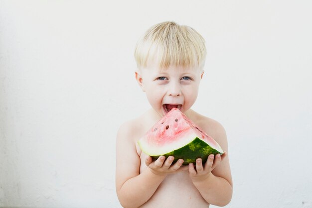 little boy eating watermelon