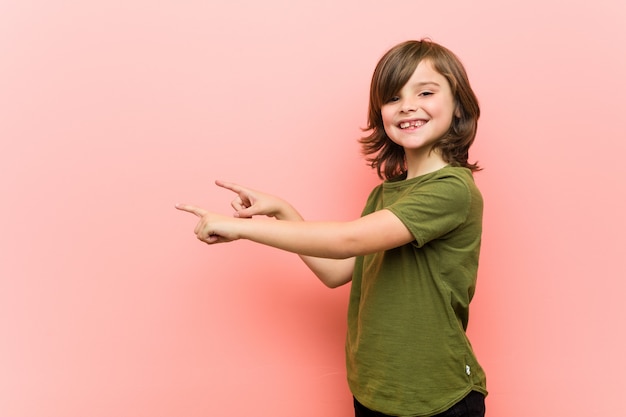 Little boy excited pointing with forefingers away.