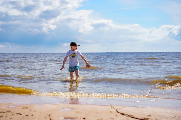 Little boy feeling cold in the sea on sunny summer day