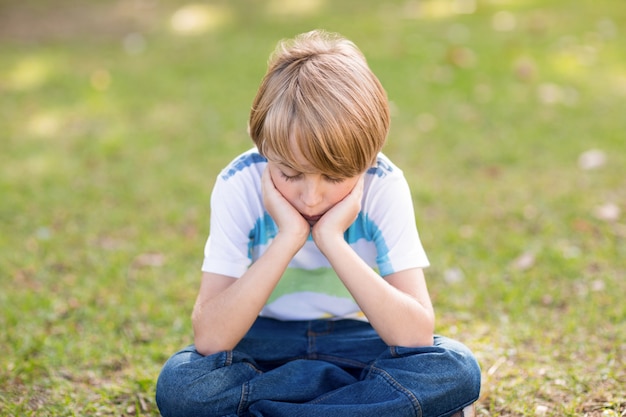 Little boy feeling sad in the park