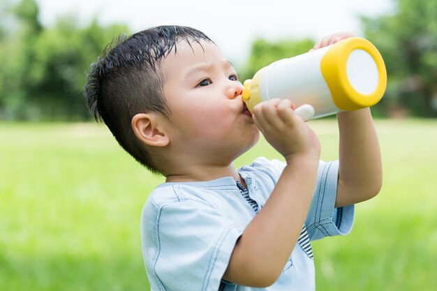 Photo little boy feeling thirsty and drink with water bottle