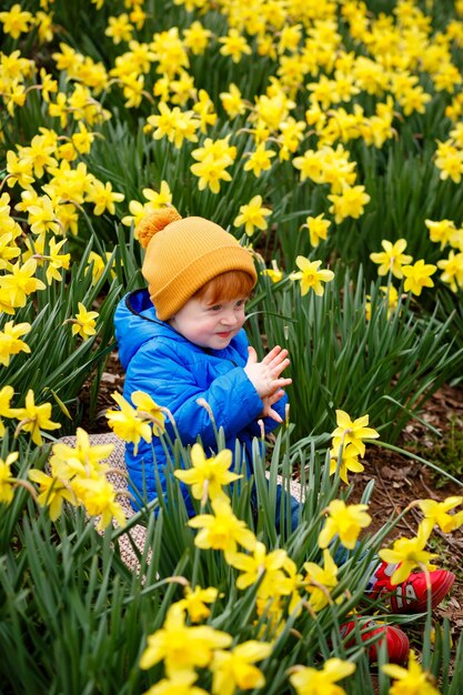 Foto un ragazzino in un campo di narcisi