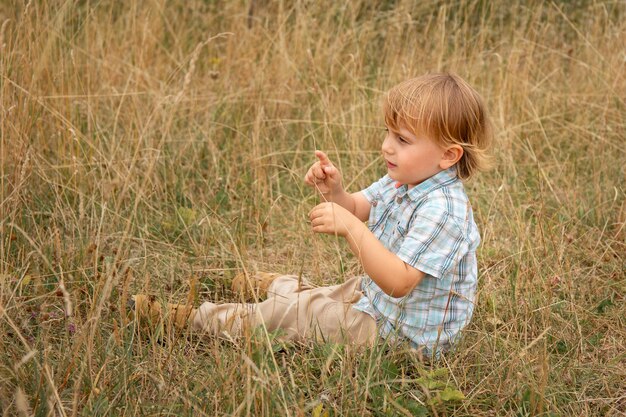 Little boy on the field in summer toddler playing outdoor child in nature