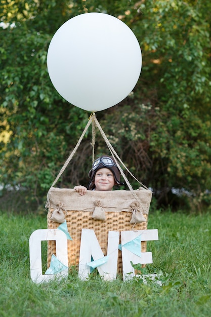 Little boy flier in a basket with a balloon