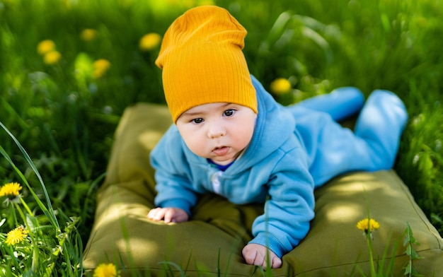 花畑の小さな男の子笑顔のかわいい男の子がカメラを見て黄色の花の背景のポートレート、クローズ アップ