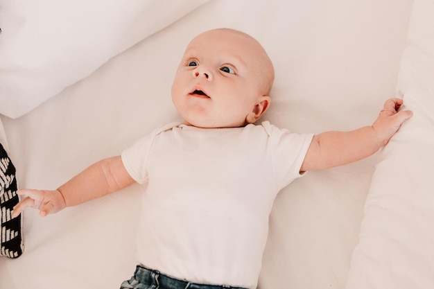 ベッドに横になっている小さな男の子面白いかわいい子赤ちゃん。楽しい遊び心のある幼児