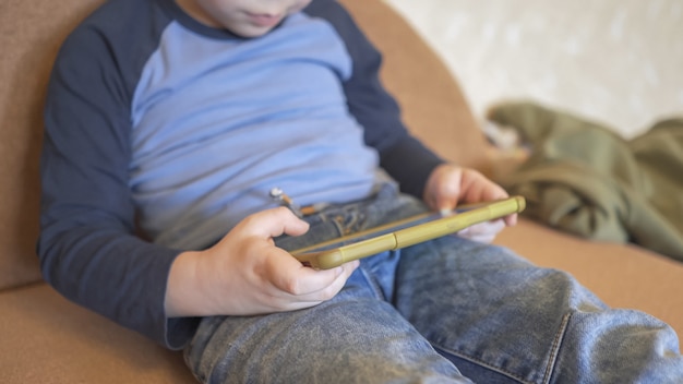 Little boy gebruikt telefoon om te spelen of te leren thuis te blijven