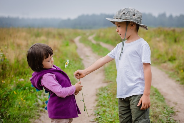 小さな男の子のギフトは彼の友人の女の子を花します。