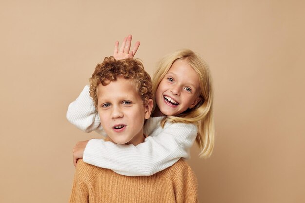 Маленький мальчик и девочка обнимаются, развлекаясь, изображая неизменный образ жизни дружбы
