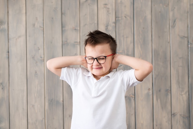 耳の痛みに苦しんでいる眼鏡の少年