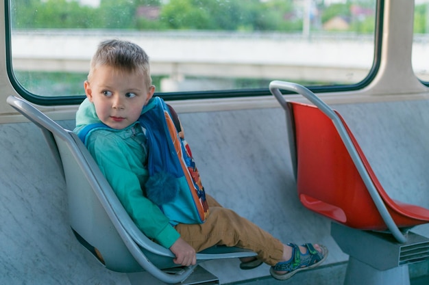 A little boy goes by himself on a tram Travel of a child in public transport