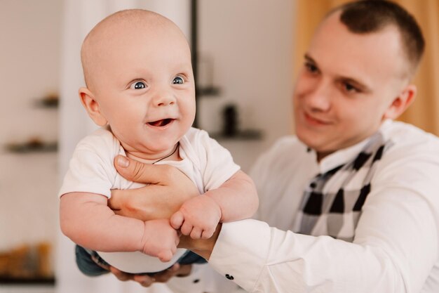 Little boy happy funny smiling laughing cute child baby, father hold lift the child. Playful toddler