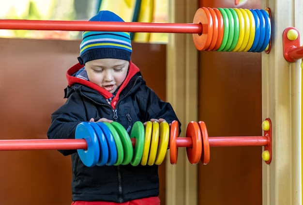 A little boy has fun playing and learning to count on a walk in the park on the playground