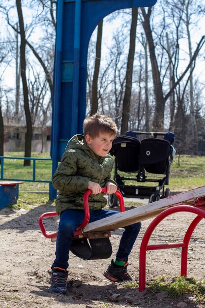 Photo little boy having fun on swing on playground happy child enjoy swinging active outdoors leisure
