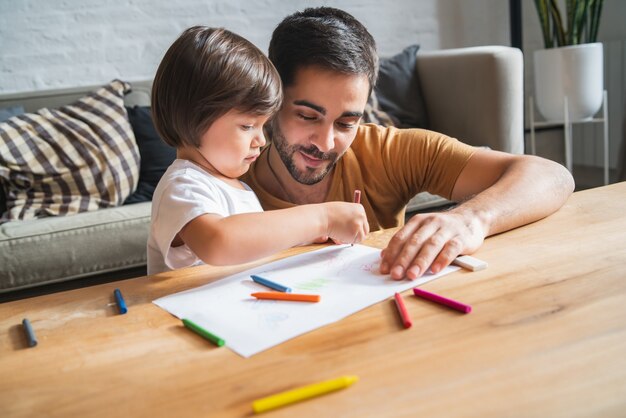 Little boy having fun with his father at home.