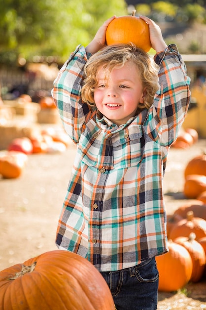 Little Boy Holding His Pumpkin at a Pumpkin PatchxA