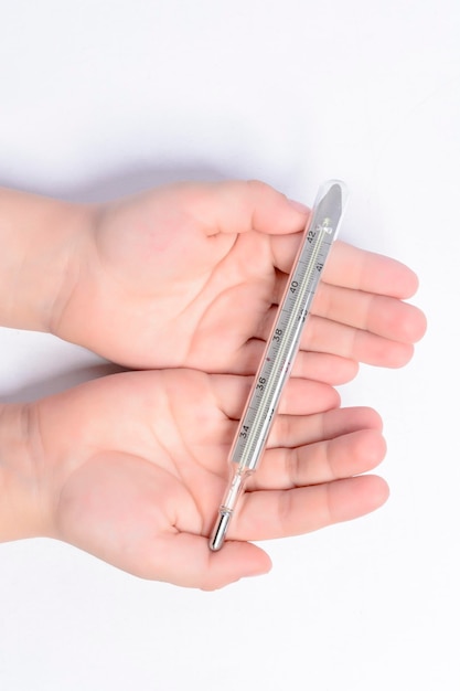 Little boy holding a thermometer in his hands on a white background