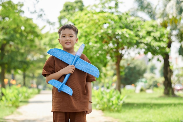 Маленький мальчик держит игрушечный самолет