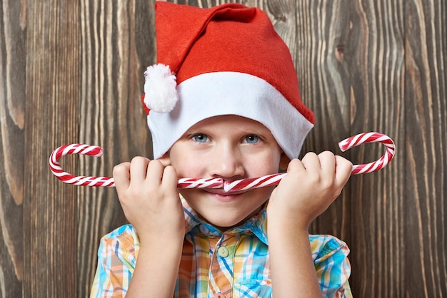 写真 2 つのクリスマス キャンデー杖と赤い帽子の少年