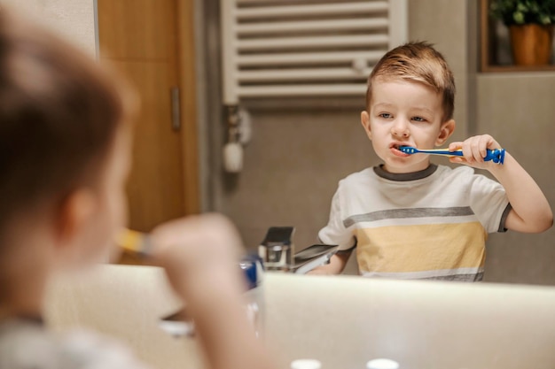 A little boy is brushing his teeth in bathroom in the morning