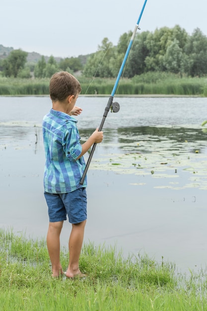 小さな男の子は川で釣り