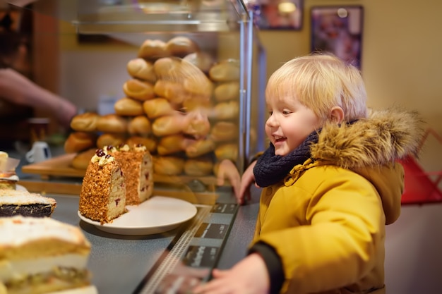 Il ragazzino sta guardando i dolci di natale in una panetteria tedesca