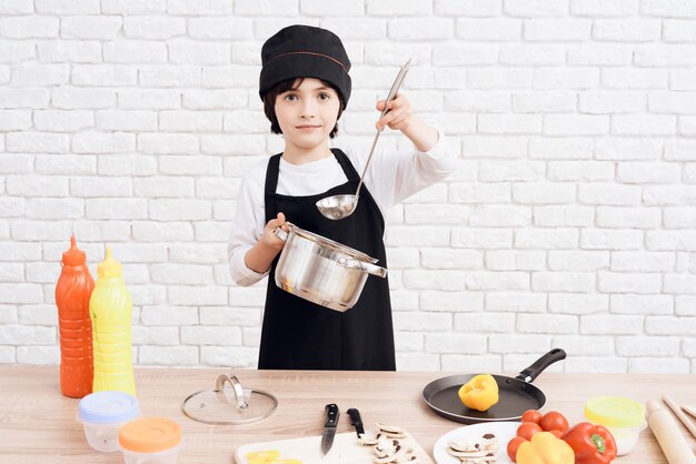 The little boy is mastering the profession of cook.