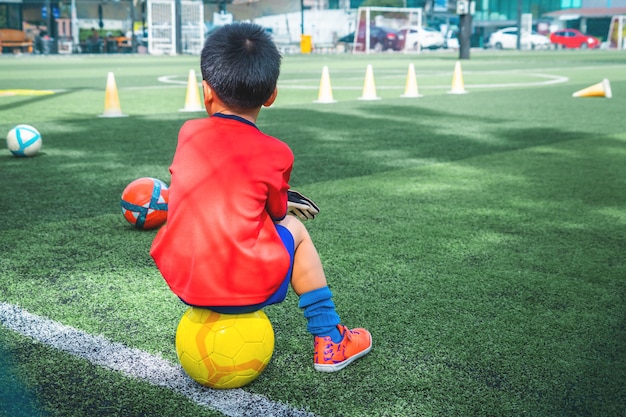 Little boy is relaxing in soccer training field