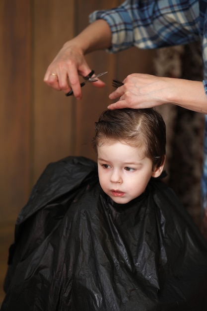 A little boy is trimmed in the hairdresser's bright emotions on his face