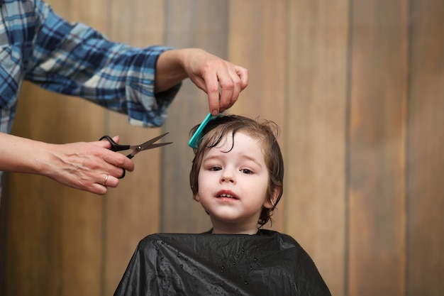 A little boy is trimmed in the hairdresser's bright emotions on his face