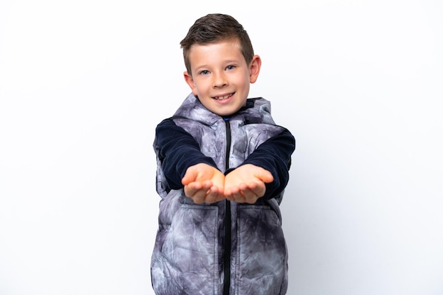 Little boy isolated on white background holding copyspace imaginary on the palm to insert an ad