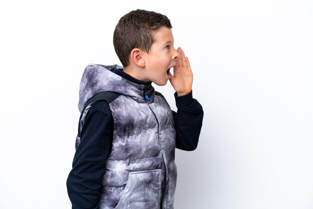 Little boy isolated on white background shouting with mouth wide open to the side