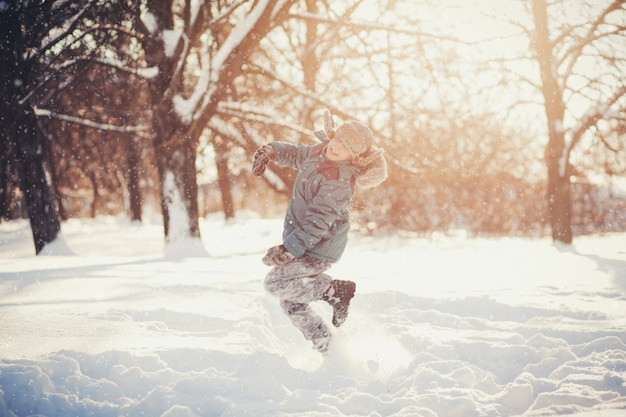 Il ragazzino che salta nel parco di inverno