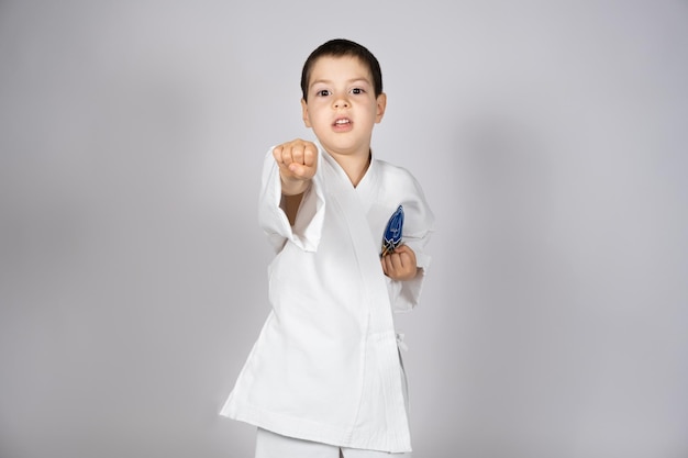 A little boy in kimono practices karate