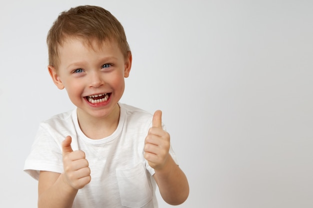 Little boy laughs and gives a thumbs up meaning that he likes it