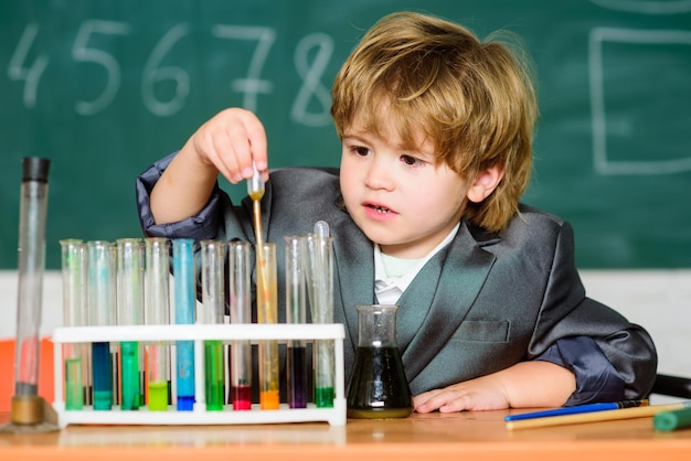 レッスン中の小さな男の子。学校に戻る。小学校の男の子。科学を勉強している学校の子供科学者。学校の実験室で化学を学ぶ小さな子供。医学の新しいアイデア。