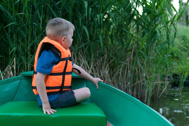 A little boy in a life jacket in a boat