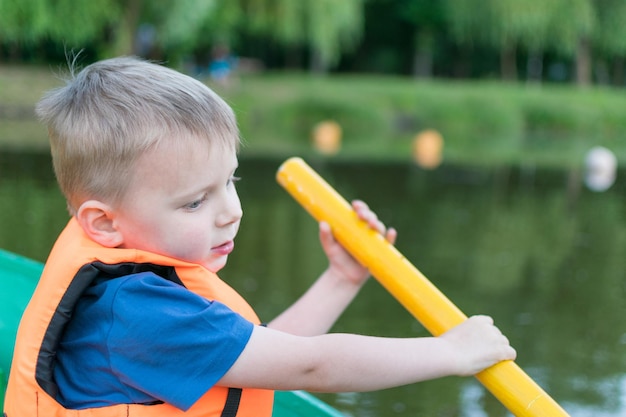 A little boy in a life jacket in a boat