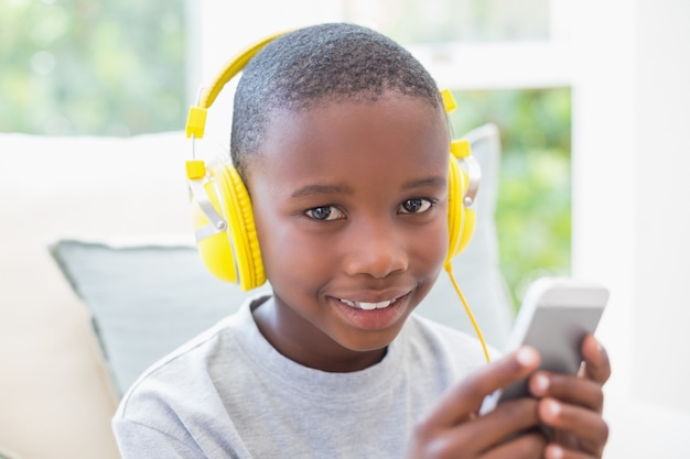 Little boy listening to music on the couch